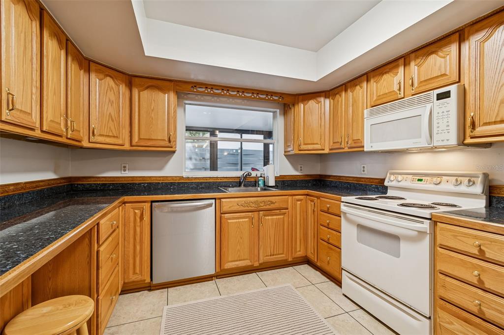 2618 Cedar View Court, Unit 95B Clearwater, FL 33761 - Photo 11 of 43 a kitchen with granite countertop cabinets stainless steel appliances a sink and a window