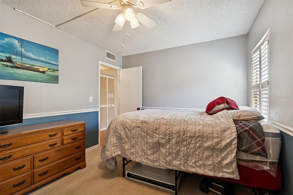 2618 Cedar View Court, Unit 95B Clearwater, FL 33761 - Photo 21 of 43 a bedroom with a bed and a flat tv screen on dresser