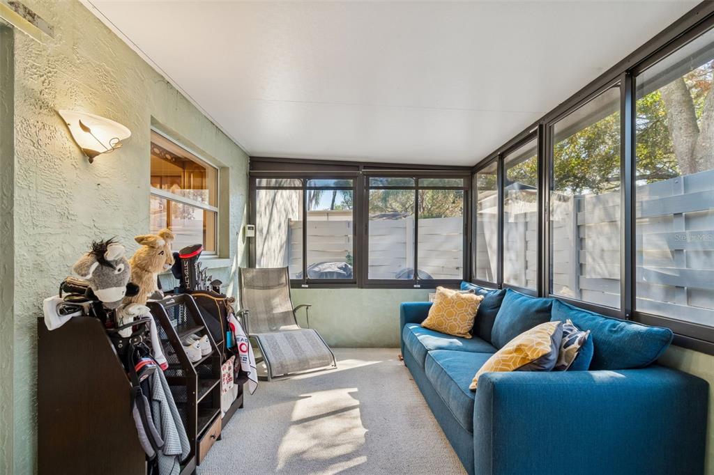 2618 Cedar View Court, Unit 95B Clearwater, FL 33761 - Photo 30 of 43 a living room with furniture and a floor to ceiling window
