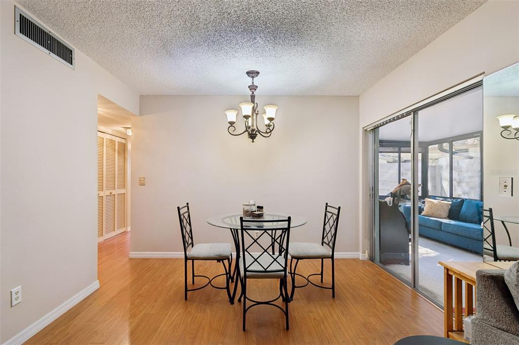 2618 Cedar View Court, Unit 95B Clearwater, FL 33761 - Photo 6 of 43 a dining room with furniture a chandelier and wooden floor