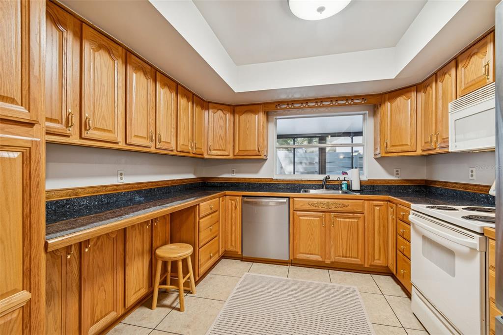 2618 Cedar View Court, Unit 95B Clearwater, FL 33761 - Photo 10 of 43 a kitchen with granite countertop a stove sink and cabinets