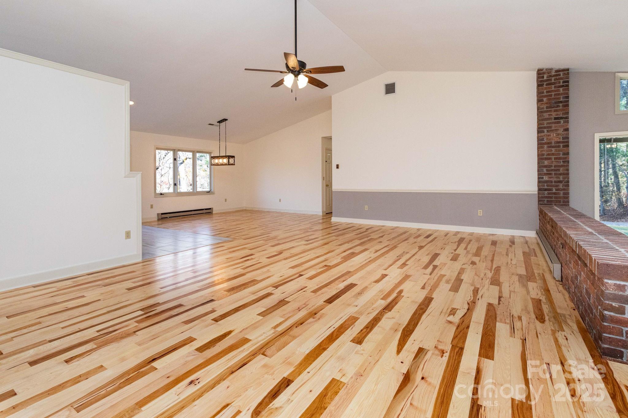84 Joe Jenkins Road Fairview, NC 28730 - Photo 12 of 26 a view of empty room with wooden floor and fan