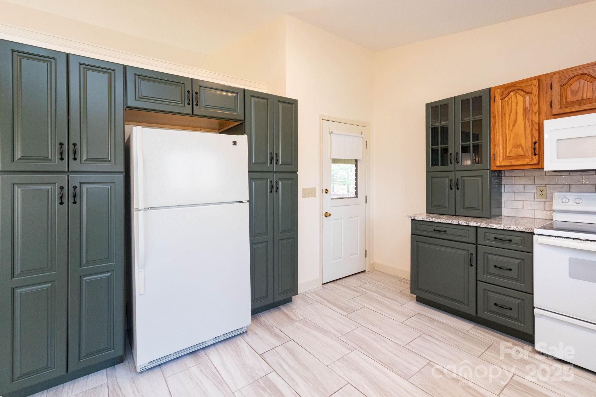 84 Joe Jenkins Road Fairview, NC 28730 - Photo 13 of 26 a kitchen with a refrigerator and cabinets