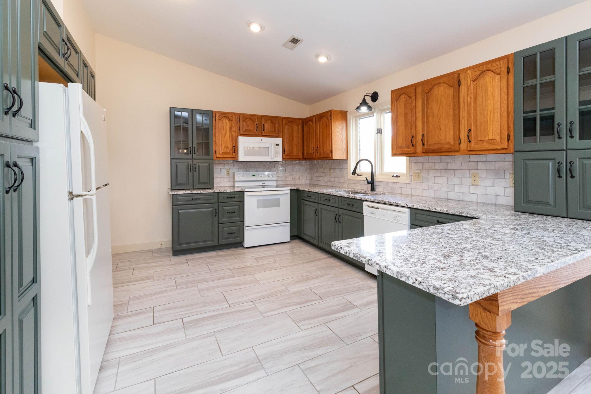 84 Joe Jenkins Road Fairview, NC 28730 - Photo 14 of 26 a kitchen with stainless steel appliances granite countertop a sink stove and refrigerator
