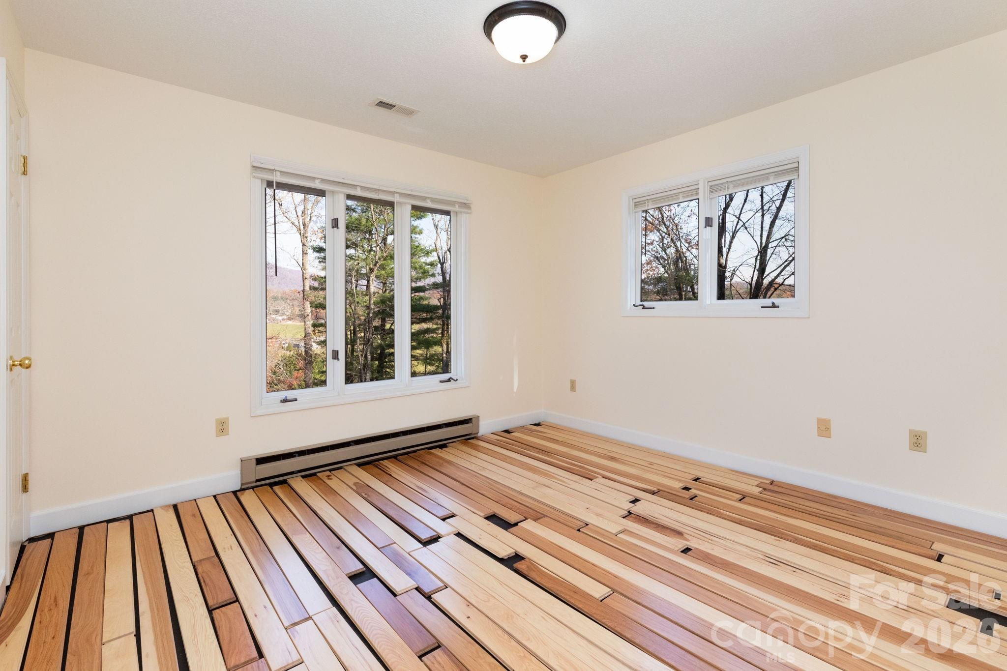 84 Joe Jenkins Road Fairview, NC 28730 - Photo 15 of 26 a view of an empty room with wooden floor and a window