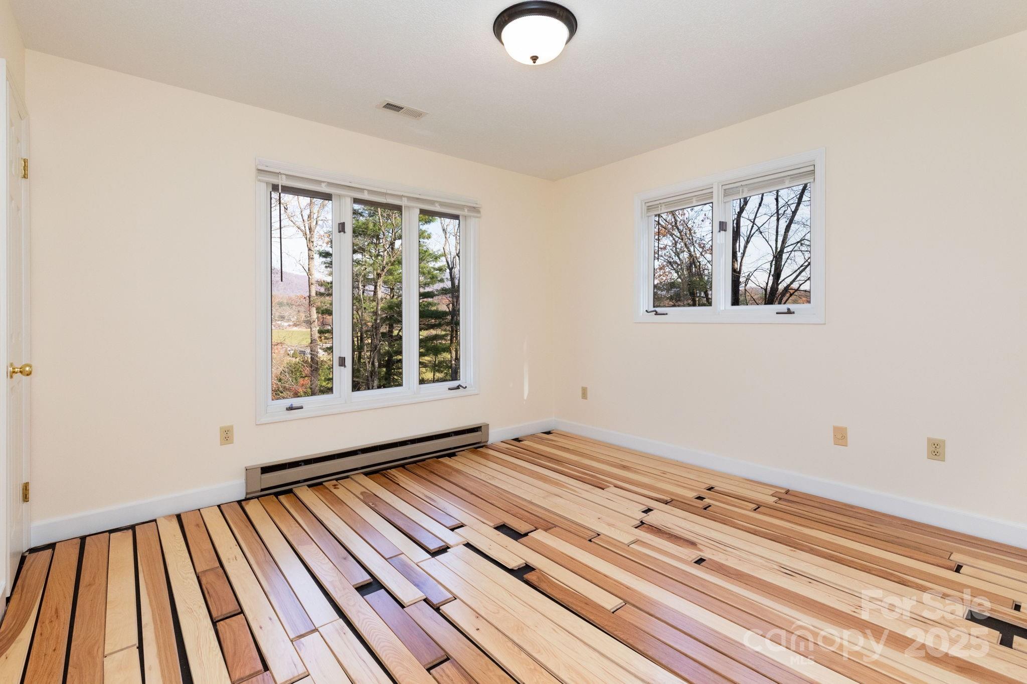 84 Joe Jenkins Road Fairview, NC 28730 - Photo 15 of 26 a view of an empty room with wooden floor and a window