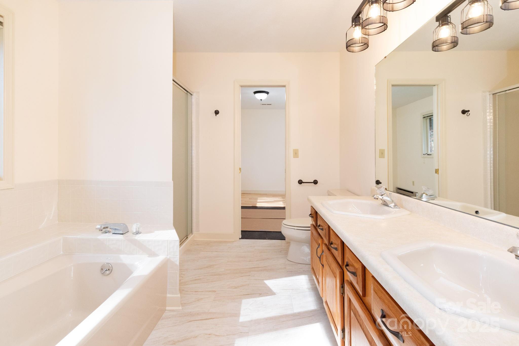 84 Joe Jenkins Road Fairview, NC 28730 - Photo 25 of 26 a spacious bathroom with a tub sink and mirror