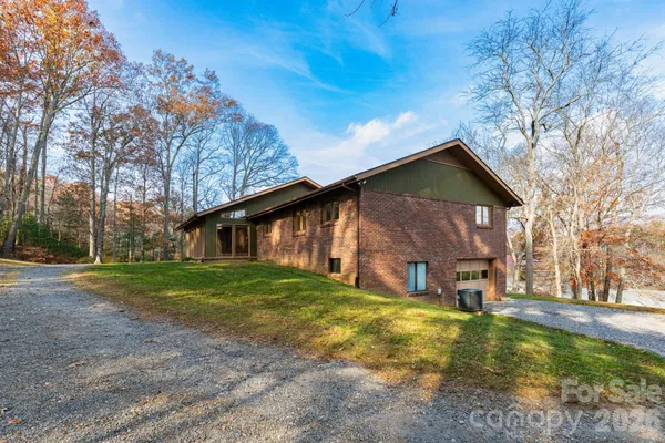 a brick building with a big yard and large trees