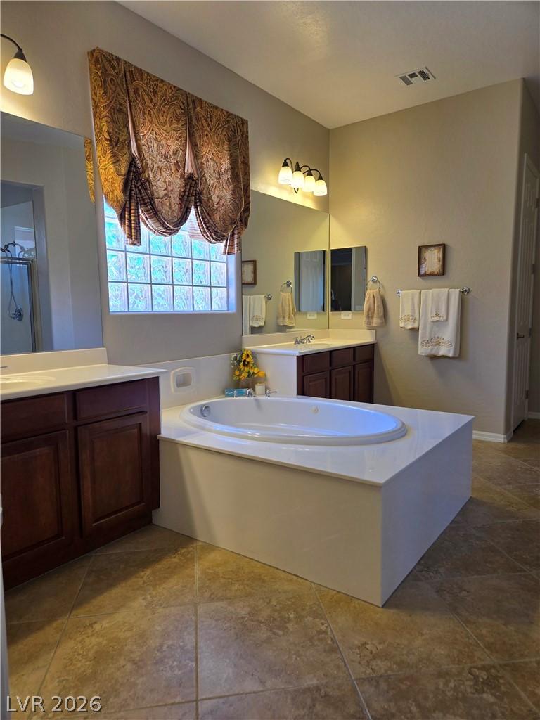 2567 Dirleton Place Henderson, NV 89044 - Photo 34 of 67 An inviting bathroom offers a soaking tub and dual vanities, perfect for unwinding after a long day.