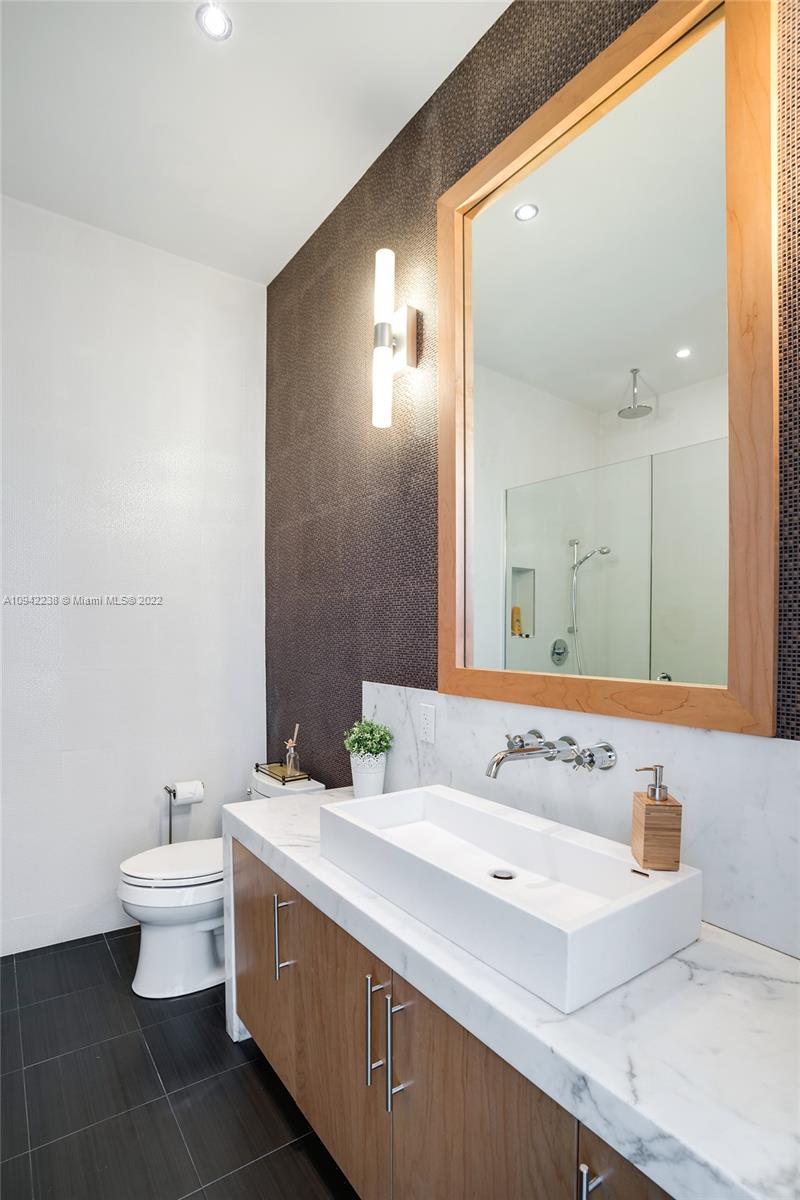 8101 Biscayne Boulevard, Unit R705 Miami, FL 33138 - Photo 13 of 32 a bathroom with a sink and a mirror