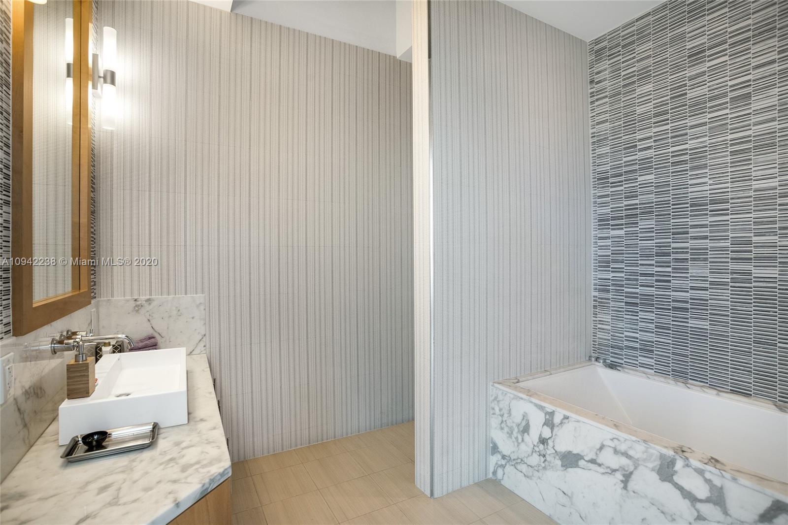 8101 Biscayne Boulevard, Unit R705 Miami, FL 33138 - Photo 14 of 32 a bathroom with a tub and sink