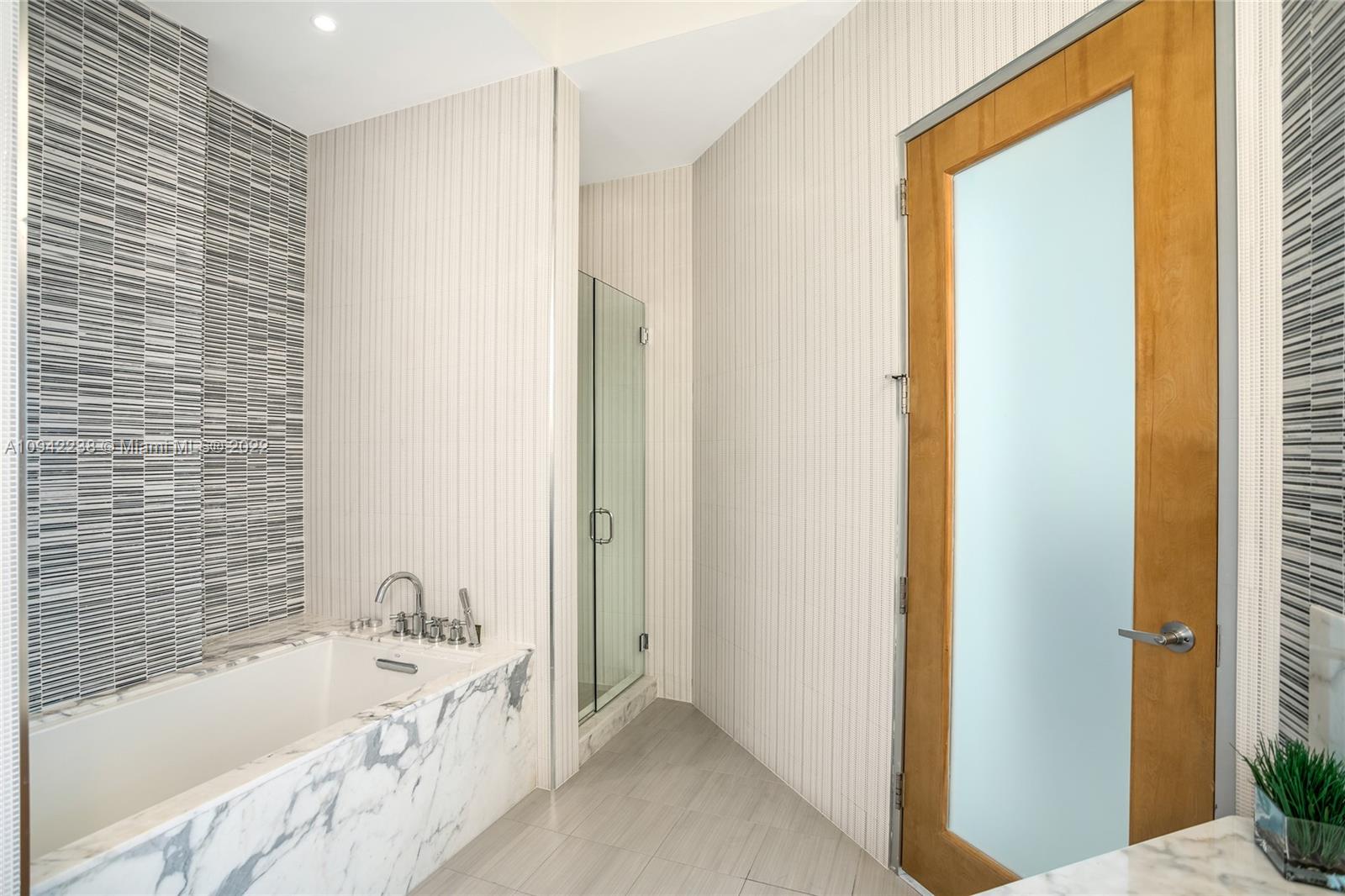 8101 Biscayne Boulevard, Unit R705 Miami, FL 33138 - Photo 15 of 32 a bathroom with a bathtub and a shower