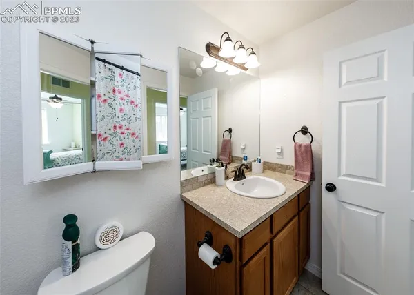 a bathroom with a sink vanity granite tub and a mirror