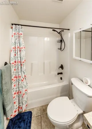 a bathroom with a toilet and a shower curtain