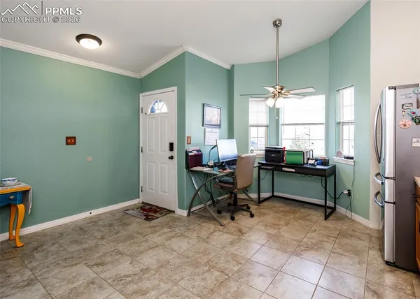 a view of a workspace with furniture and a window