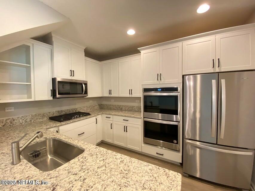 534 Pine Bluff Drive St. Augustine, FL 32092 - Photo 12 of 30 a kitchen with granite countertop a refrigerator sink and microwave