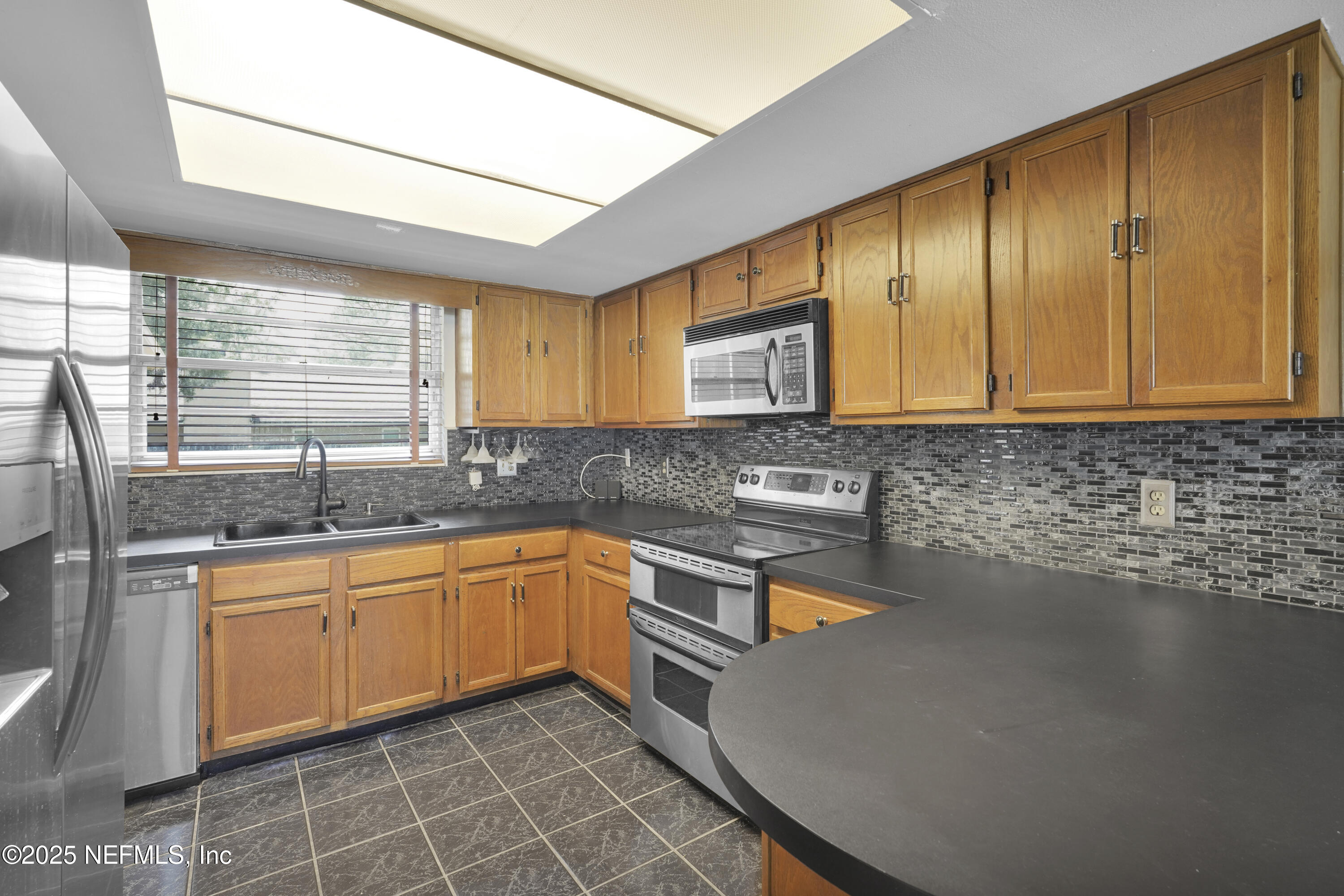 1610 Derringer Road Jacksonville, FL 32225 - Photo 12 of 29 a kitchen with stainless steel appliances granite countertop sink stove and cabinets