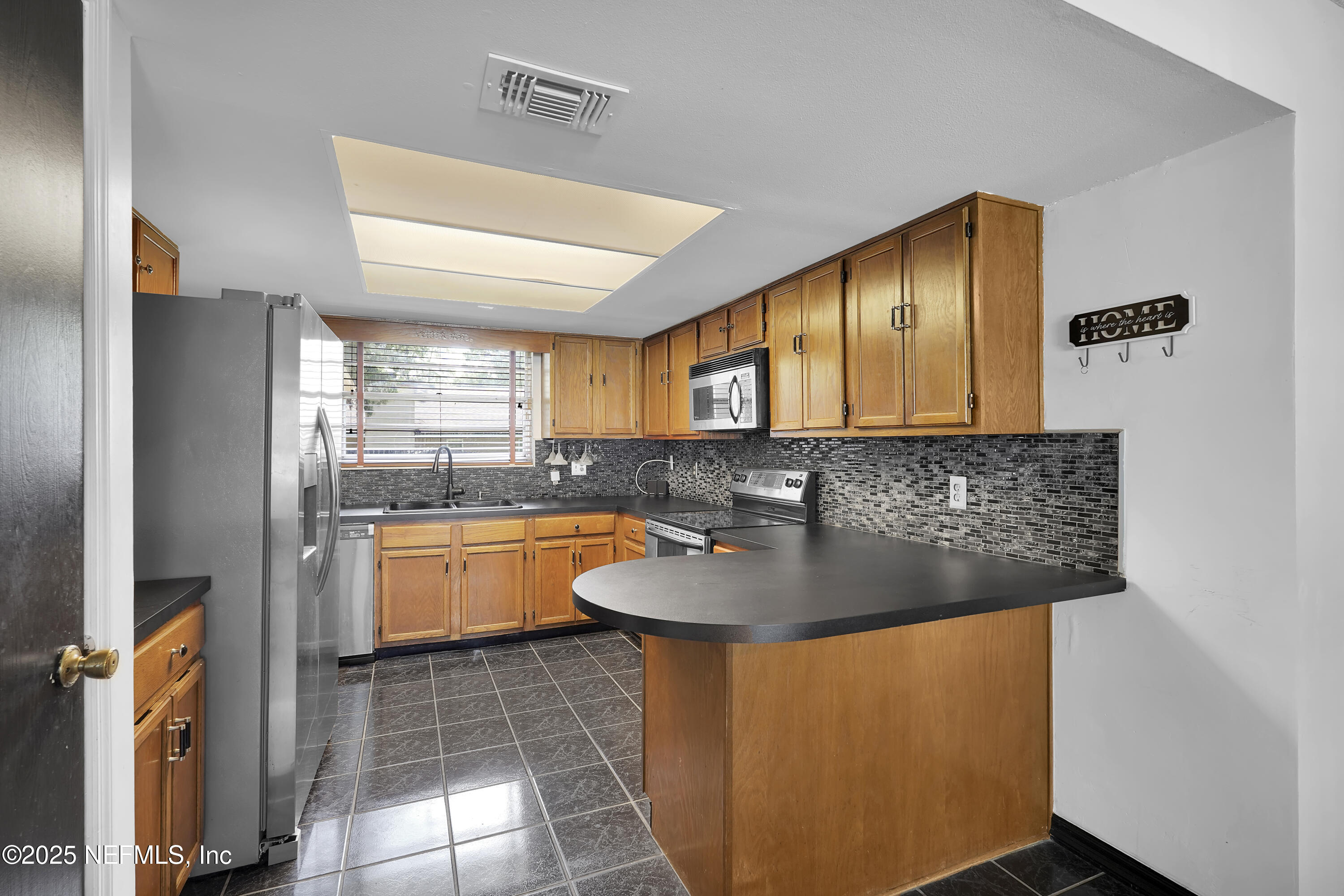 1610 Derringer Road Jacksonville, FL 32225 - Photo 13 of 29 a kitchen with stainless steel appliances granite countertop a sink and a refrigerator