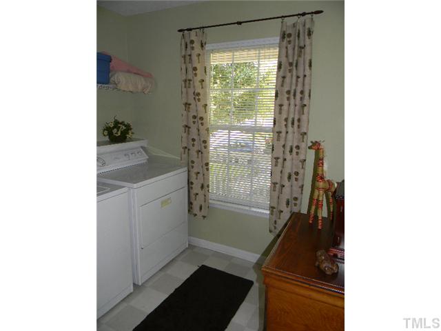 5028 Silverdene Street Raleigh, NC 27616 - Photo 12 of 25 Laundry room is at the end of the bedroom hall (away from the master bedroom)...great space w/ shelving and a window! You could easily set up an ironing board or put up a folding table for a fully functional space!