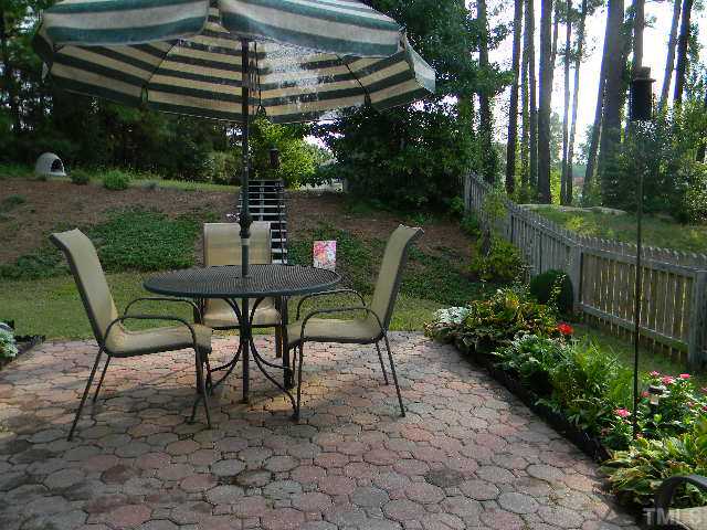 5028 Silverdene Street Raleigh, NC 27616 - Photo 18 of 25 Back patio w/ pavers is landscaped on either side for colorful floral surprises throughout the year!