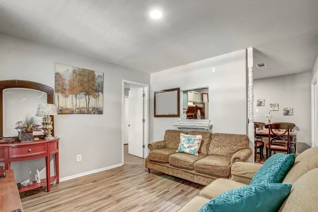 a living room with furniture and a wooden floor