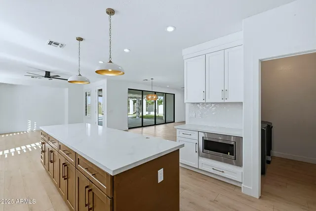 a kitchen that has a lot of cabinets and a wooden floor