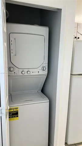 a view of an empty room with wooden floor and closet