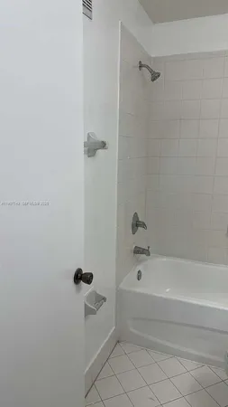 a white toilet and tub sitting next to a bathroom sink