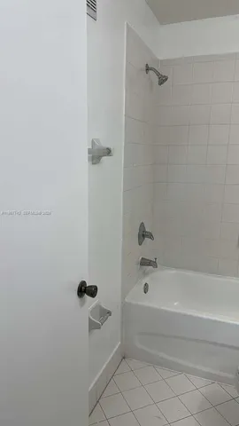 a white toilet and tub sitting next to a bathroom sink