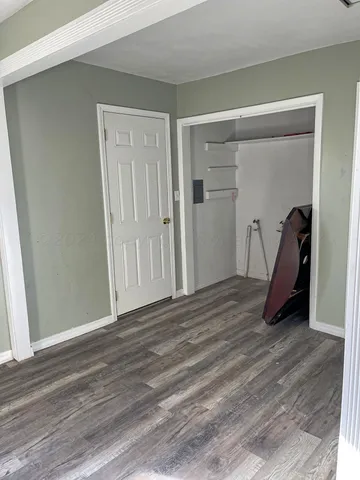a view of a room with wooden floor and a ceiling fan