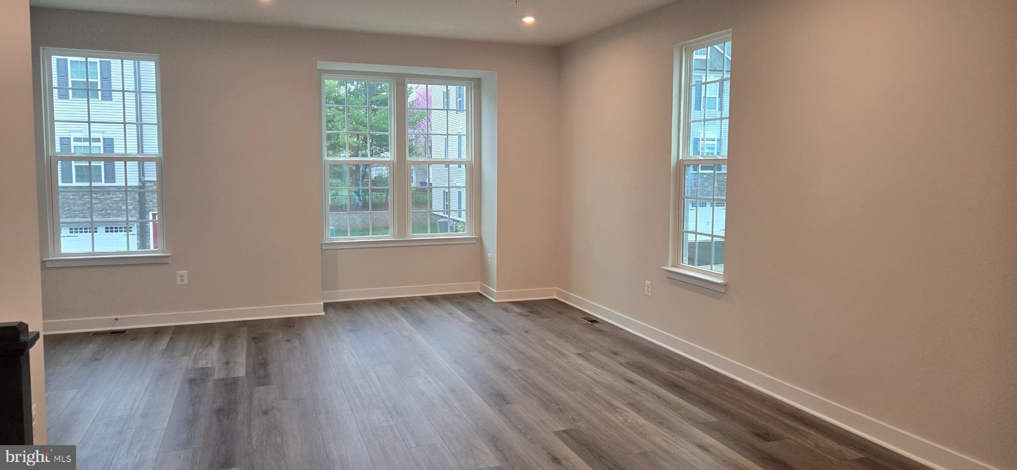 357 Marquis Street Frederick, MD 21702 - Photo 11 of 23 a view of an empty room with wooden floor and a window