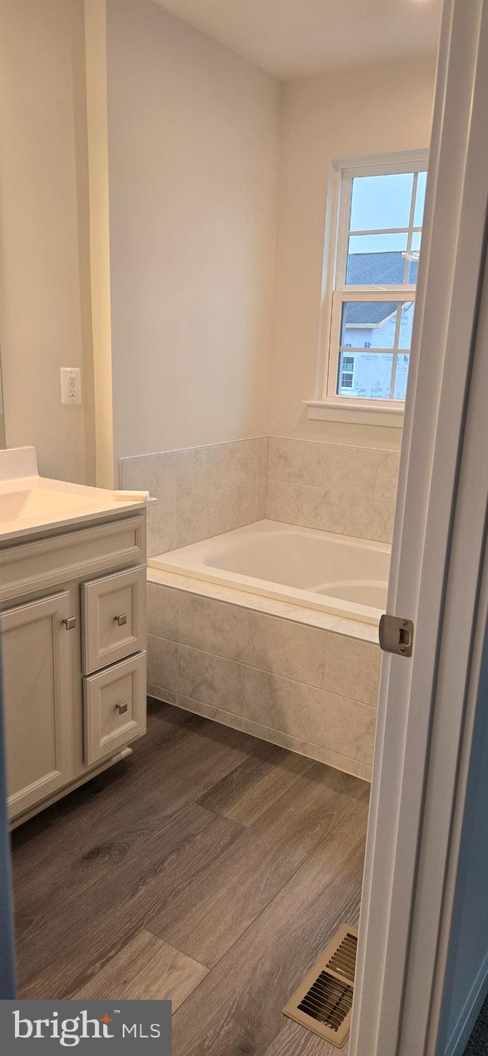 357 Marquis Street Frederick, MD 21702 - Photo 16 of 23 a bathroom with a double vanity sink a mirror and a bathtub