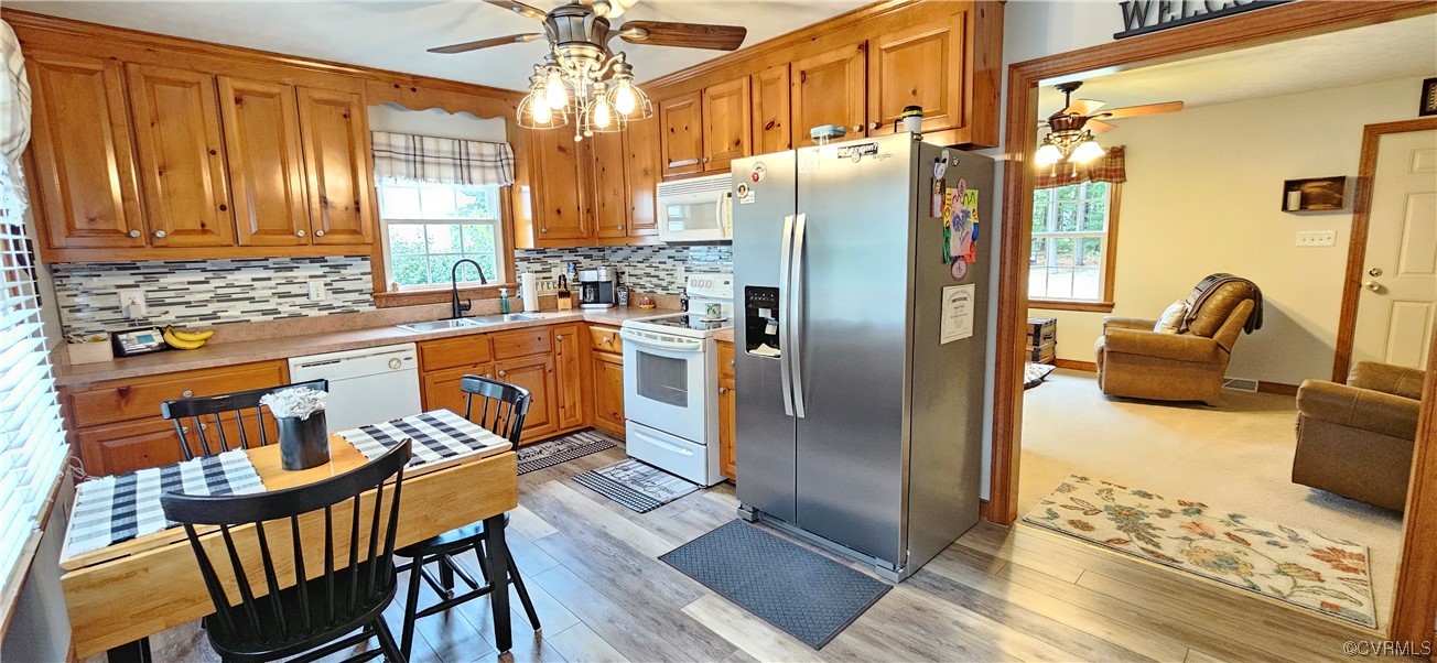 2405 Beulah Church Road St. Stephens Church, VA 23148 - Photo 11 of 18 a kitchen with stainless steel appliances granite countertop a refrigerator a stove and a dining table with wooden floor