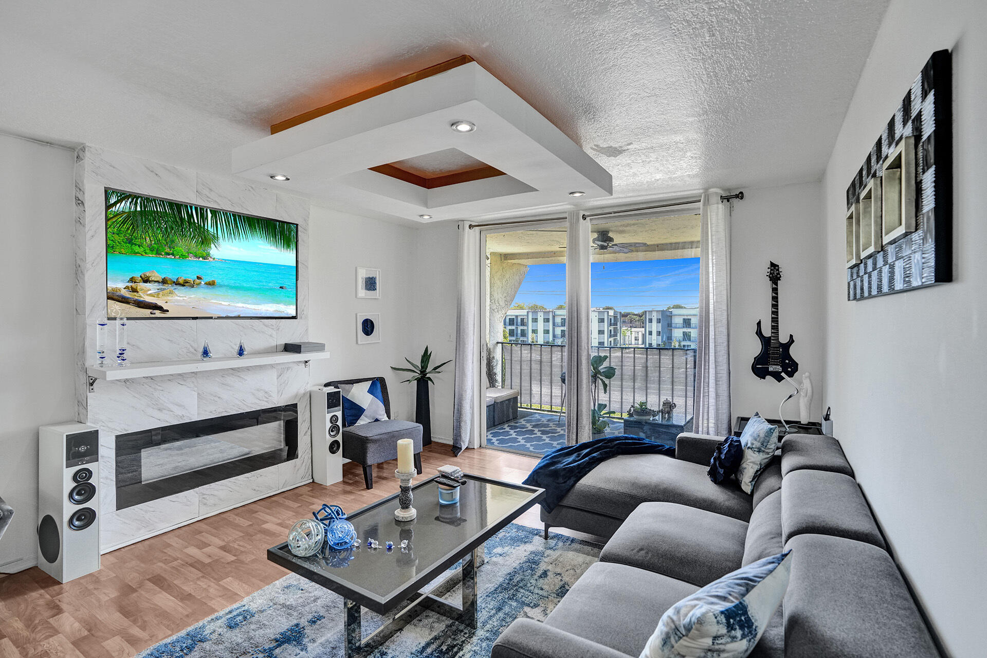 6193 Rock Island Road, Unit 405 Tamarac, FL 33319 - Photo 13 of 42 a living room with furniture a flat screen tv and a floor to ceiling window