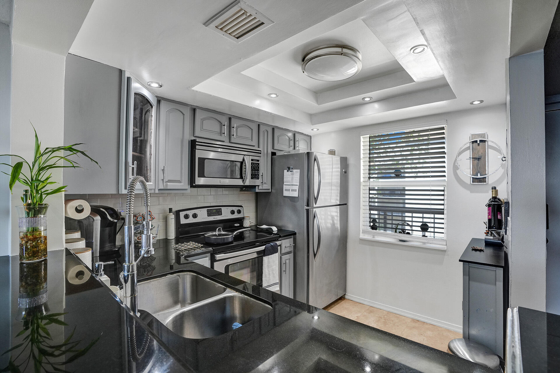 6193 Rock Island Road, Unit 405 Tamarac, FL 33319 - Photo 29 of 42 a kitchen with stainless steel appliances granite countertop a sink a stove and a refrigerator