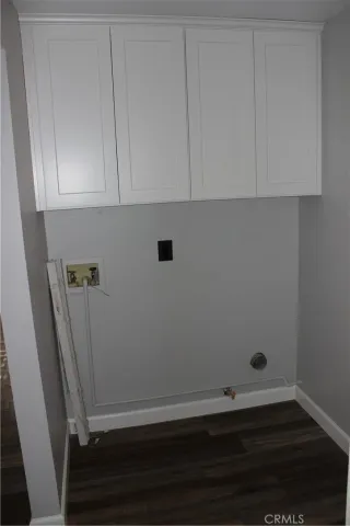 an empty room with wooden floor and cabinets