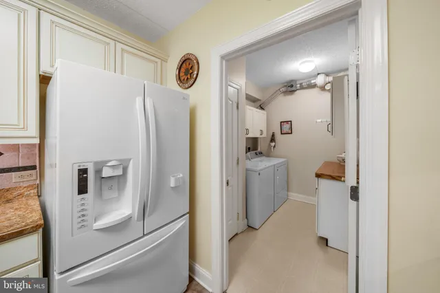 a bathroom with a refrigerator a sink and mirror
