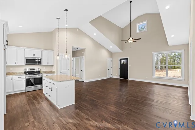 a large kitchen with cabinets wooden floor stainless steel appliances and a ceiling