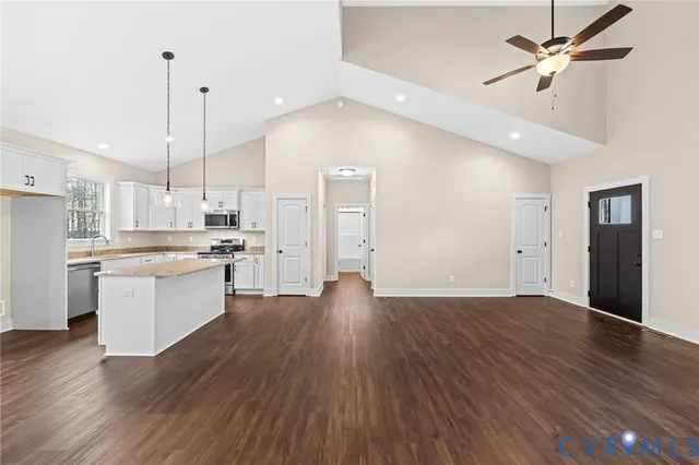 a view of kitchen with refrigerator wooden floor and a ceiling fan