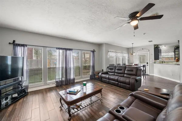 a living room with furniture and a flat screen tv with wooden floor