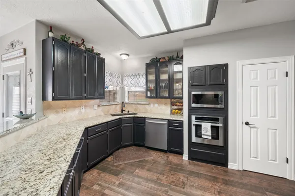 a kitchen with stainless steel appliances granite countertop a sink stove and refrigerator