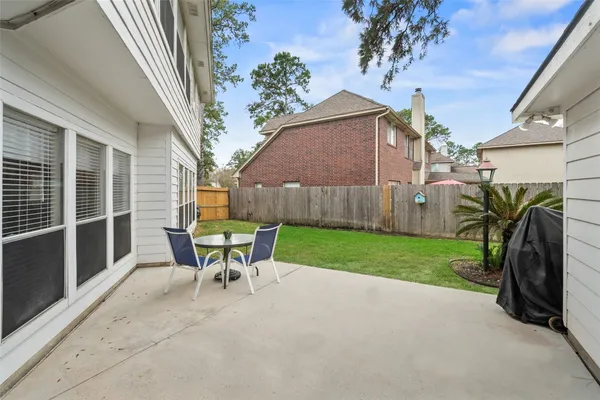 a view of a chair and table in backyard of the house