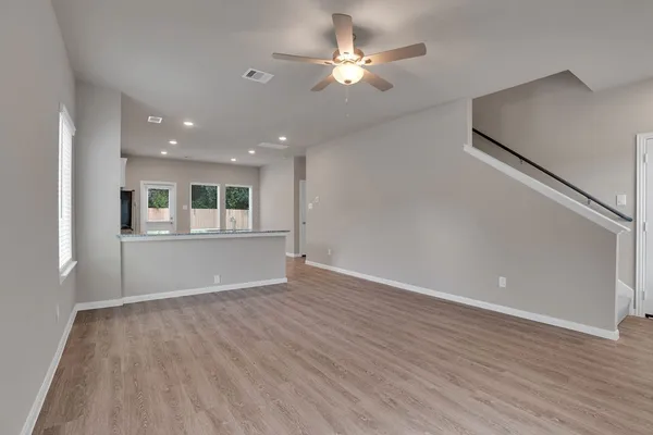 a view of an empty room with window and wooden floor