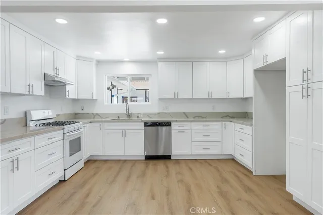 a kitchen with granite countertop white cabinets and white appliances