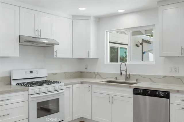 a kitchen with cabinets appliances a sink and a counter top