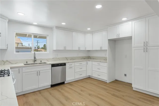 a kitchen with a sink cabinets and wooden floor