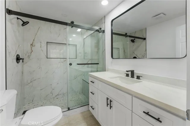 a bathroom with a sink a toilet and shower