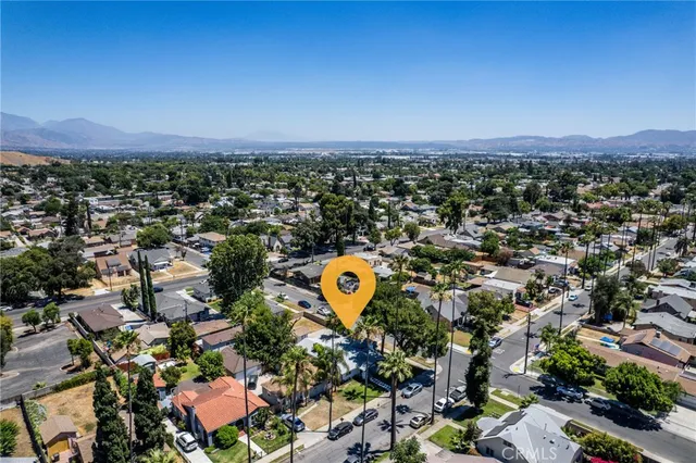 an aerial view of a city with lots of residential buildings and mountain view in back