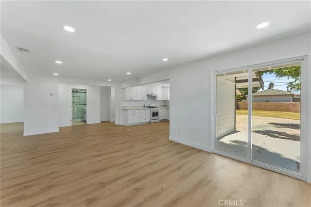 a view of empty room with wooden floor and window