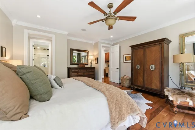 a spacious bedroom with a large bed a chandelier and dresser